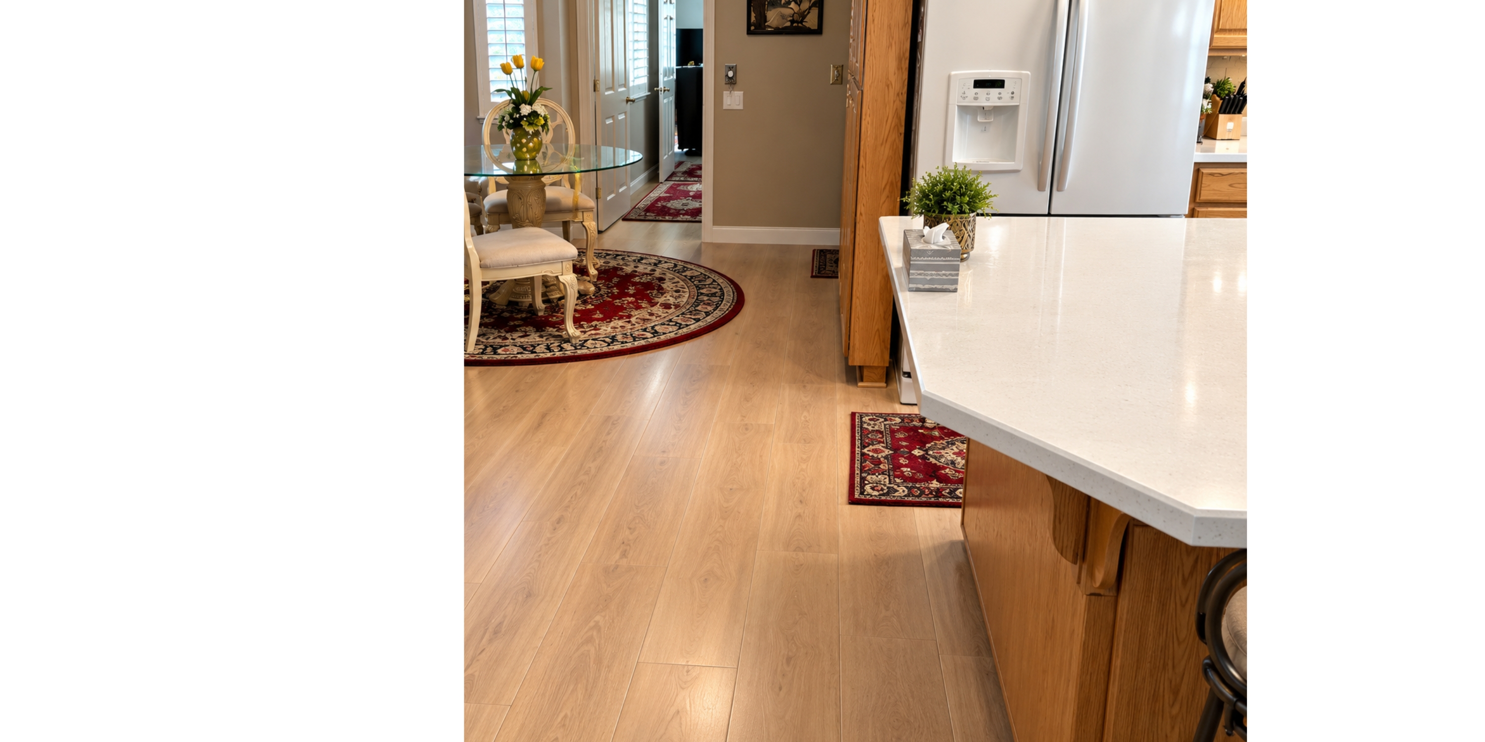Light wood-look floors in a kitchen with an area rug