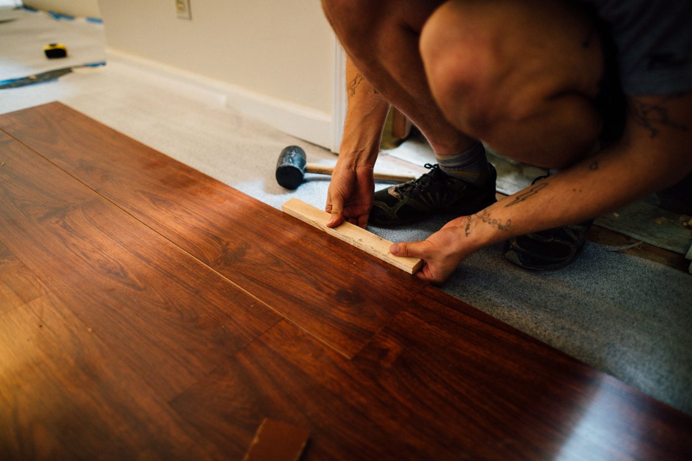 Rays installer fitting wood-look flooring planks into place