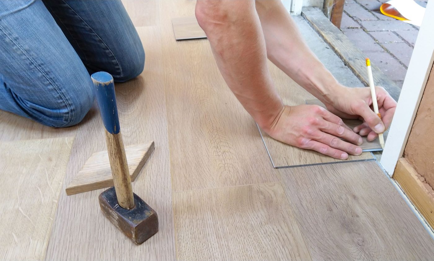 Rays installer measuring and marking wood flooring planks