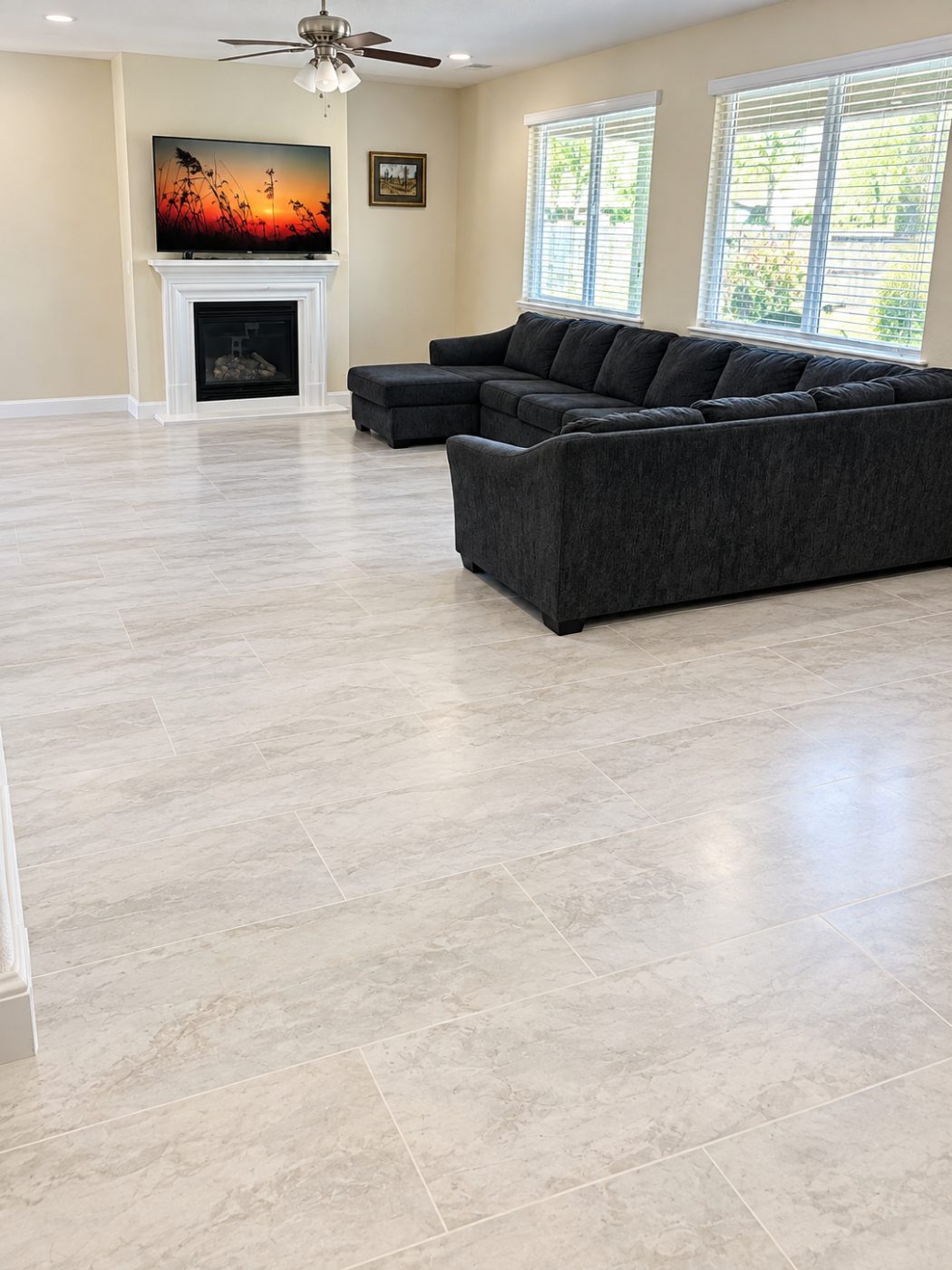Large-format stone-look luxury vinyl plank in a living room with a fireplace